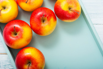 apples at blue tray, white wood table