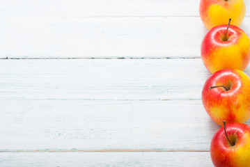 apple fruits in a row, white wooden table background