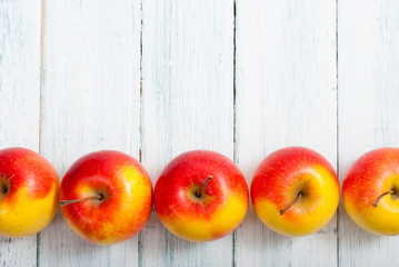 apple fruits in a row, white wooden table background