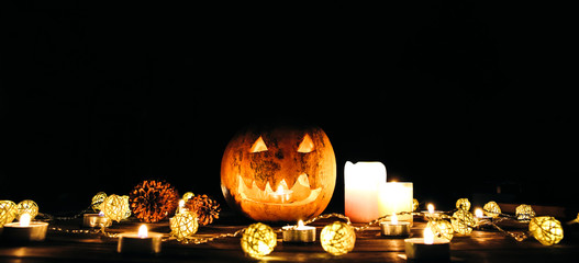 Halloween pumpkin in the darkness. Lights lamps and candles. Mystical autumn holiday. Festive details. Trick-or-treat tradition. All Saints day in October.