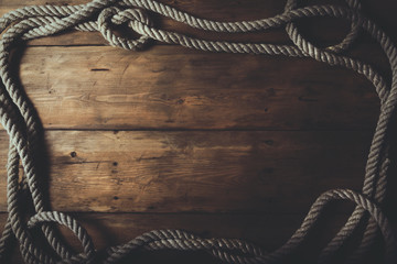 rope frame on old brown wooden plank background