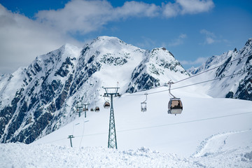 Fototapeta na wymiar Cable car and beautiful day of mountain cover by snow and blue sky at Stubai Gletscher ski area, a famous spot for ski in spring and winter.