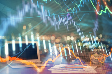 Financial graph colorful drawing and table with computer on background. Double exposure. Concept of international markets.