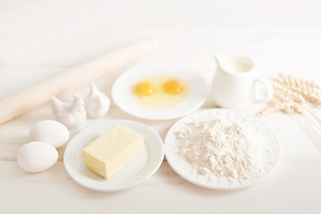 flour, eggs, butter and milk on a white wooden background, ingredients for baking