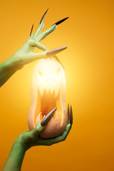 Image of green zombie hand with pumpkin ,