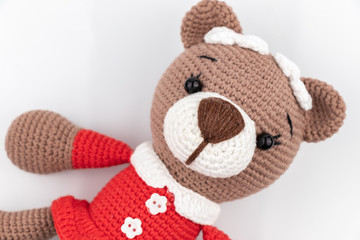 Funny handmade knitted toy bear .on white background. Amigurumi toy. Crochet stuffed animals.
