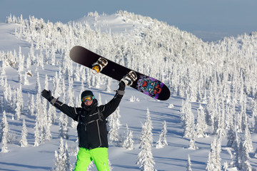a freerider snowboarder stands in the background of a beautiful mountain valley after heavy...