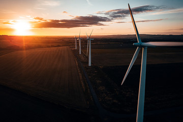 Aerial of wind turbines at sunrise in the English countryside with a dramatic sky