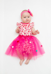 Portrait of a sweet infant wearing a pink tutu and headband bow, isolated on white
