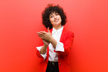 young pretty afro woman feeling happy and successful, smiling and clapping hands, saying...