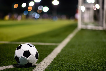 Typical soccer ball on football field next to the goal
