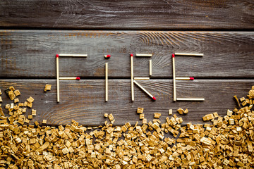 Fire in woodes concept with fire text and kindling frame on wooden background top view