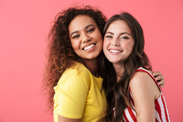 Image of positive multinational girls smiling together at camera