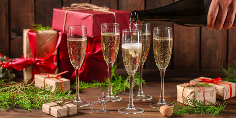 champagne and new year or christmas (champagne glass, sparkling wine and gifts on the table) menu concept. food background. copy space. Top view
