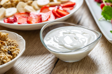 Yogurt in a glass  bowl with healthy breakfast on table