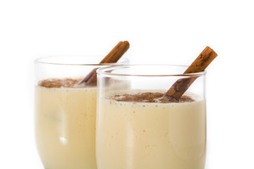 Homemade eggnog with cinnamon in glass isolated on white background. Typical Christmas dessert.