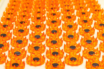 Acupuncture massager-applicator magnets for intense exposure. Concept of health care, cervical disease, osteochandrosis. Macro view, orange background