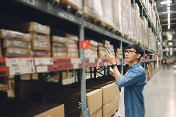 Portrait Asian men, staff, product counting Warehouse Control Manager Standing, counting and inspecting products in the warehouse