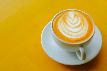 Latte Coffee art on the wooden table yellow