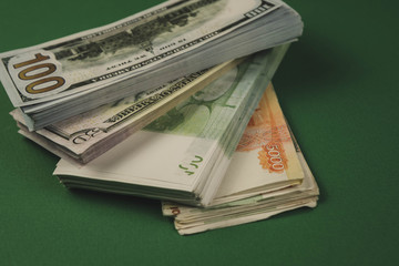 several wads of cash lying on top of each other on a green background