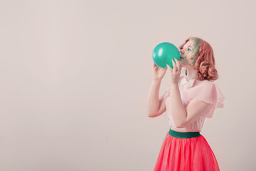 happy girl clown with green balloon on white background