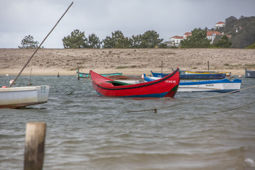View of beach in lagoon on Nazare with traditional fishing boats, in Portugal