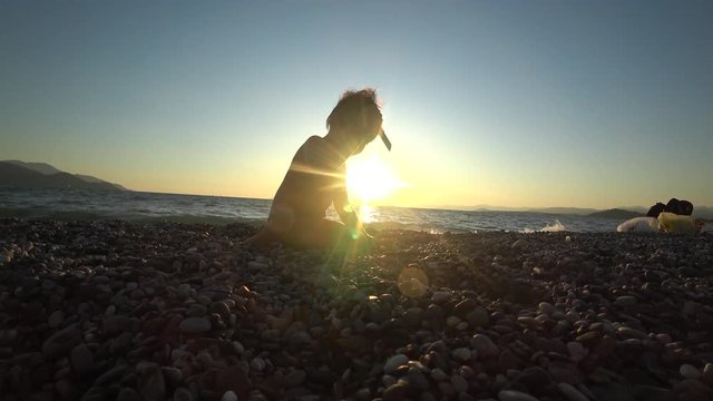 4K Child operates with knife sitting against the declining sun