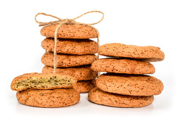Homemade cookies. Five sweet cookie made from oatmeal flour, stacked and tied with linen rope in rustic style and six next. Tasty biscuit close-up isolated on white background.