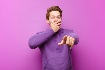 young red head man laughing at you, pointing to camera and making fun of or mocking you against...