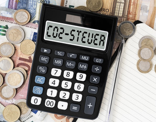 close-up of text CO2 Steuer, German for carbon tax, on display of pocket calculator against euro...