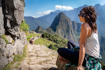 Tourist contemplating the beautiful landscape of Machu Picchu. At the bottom you can see the mountain Huayna Picchu. Archaeological site, UNESCO World Heritage - obrazy, fototapety, plakaty