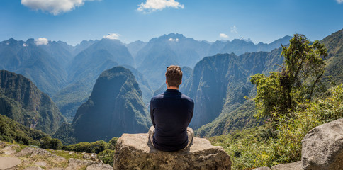 A man staring at the amazing landscape of Machu Picchu. Archaeological site, UNESCO World Heritage,...