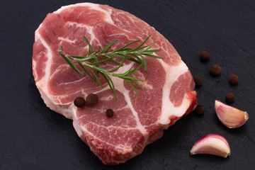 Raw meat,  steak with spices on black background