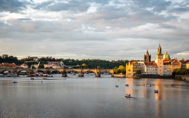 Prague and the Vlatava River, Czech Republic. Urban landscape of the famous landmark Charles Bridge and Old Town Bridge Tower at dusk.