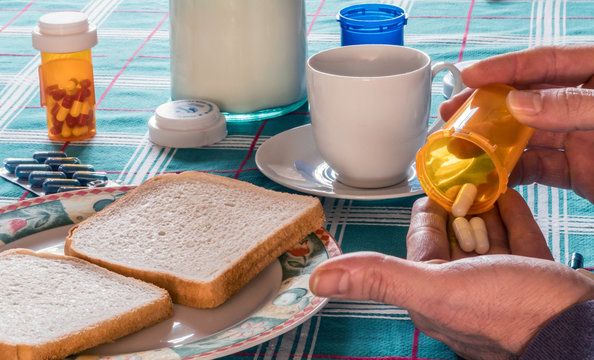Person takes medication during breakfast, conceptual image