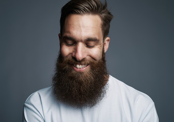 Stylish young man standing against a gray background