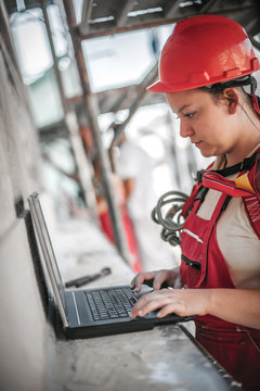 Female architect engineer inspects the construction site on laptop computer