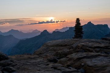 Naklejka premium stone pillar at sunset in the Swiss Alps
