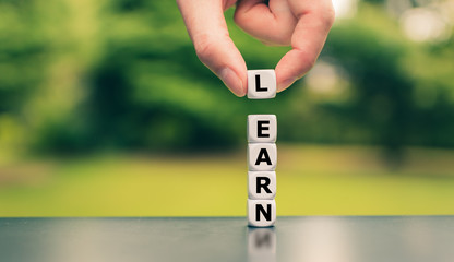 Learn or earn? Hand lifts a dice and changes the word 
