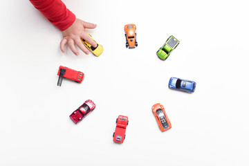 Child chooses his favourite toy car from selection of toys