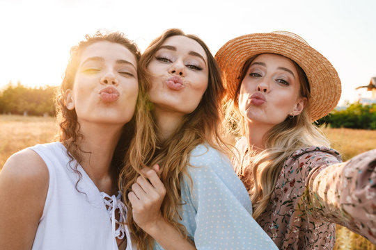 Photo of cheerful caucasian women taking selfie photo while making kiss face