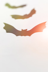 Halloween decorations with paper bats on white background. Halloween and decoration concept. Lens flare effect. Flat lay, top view, copy space