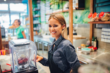 Portrait of a charming smiling waitress working at small business shop.