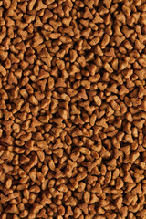 Dry pet food texture background. Medium size triangular pieces. Food pattern. Chewing treats for pets.