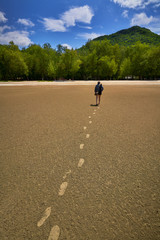 woman walk on sand beach in island by daytime