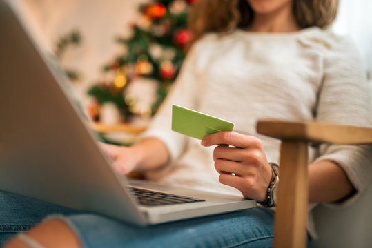 Close-up image of a woman buying Christmas present online.