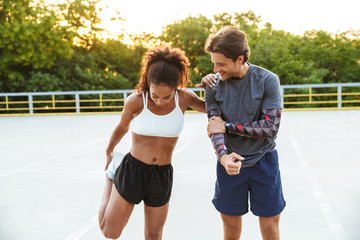 Obraz premium Sports couple man and woman make stretching exercises