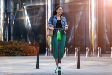 Carefree young woman riding an electric scooter © pikselstock