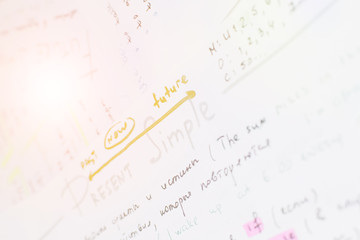 Close-up handwriting English grammar rules on white sheet of paper. Lens flare effect