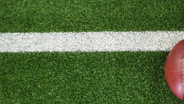 Overhead slider view of a yard line and an American football